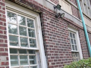 Brick wall leaning outward due to corroding steel angles at window heads