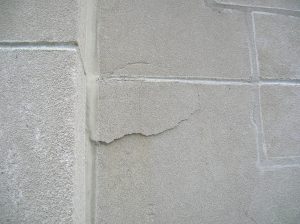 Spalling limestone, held on only by sealant on one side
